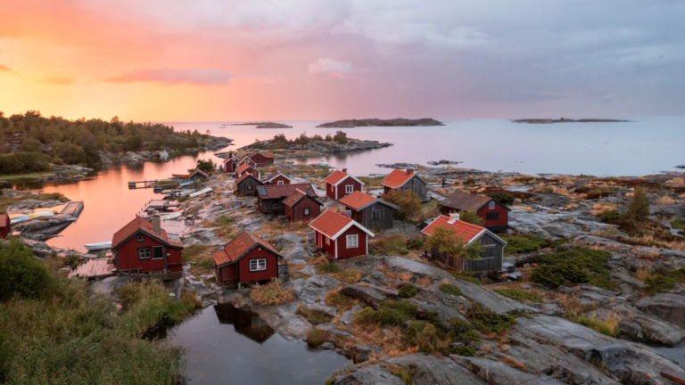Blick auf schwedische Holzhäuser am Wasser